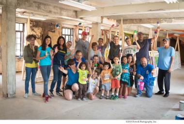 group of people stand in unfinished building