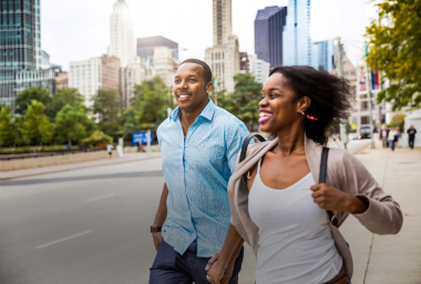 two people run along sidewalk