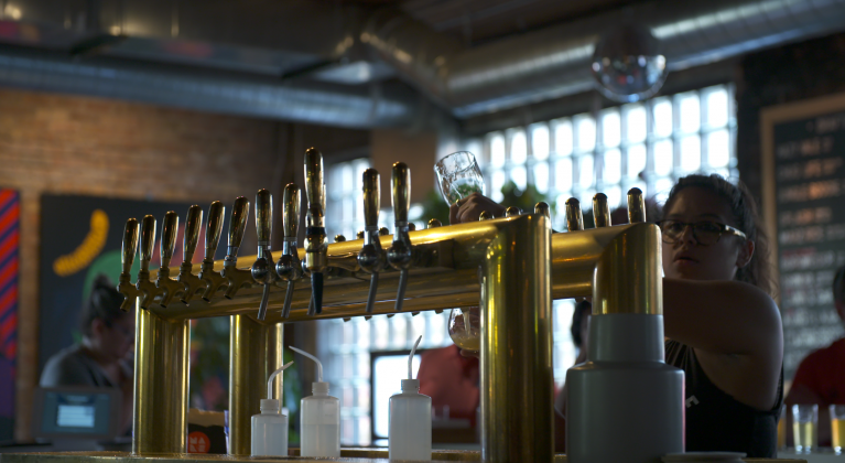 A woman pours draft beer