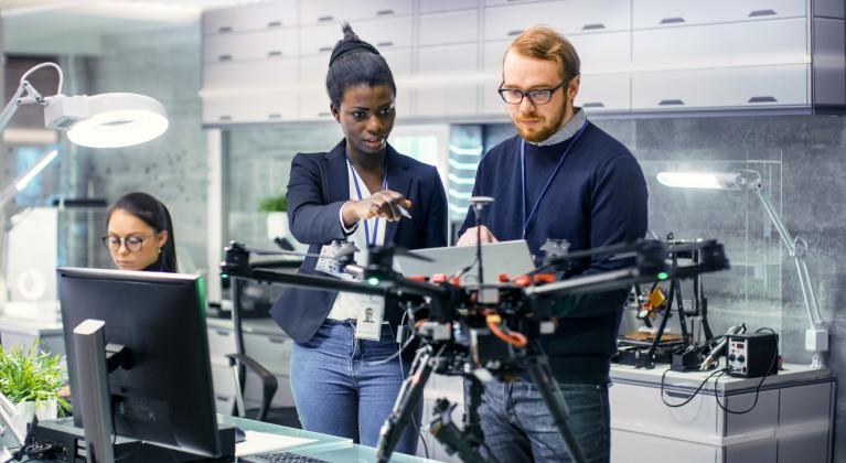 two people look and point at piece of equipment