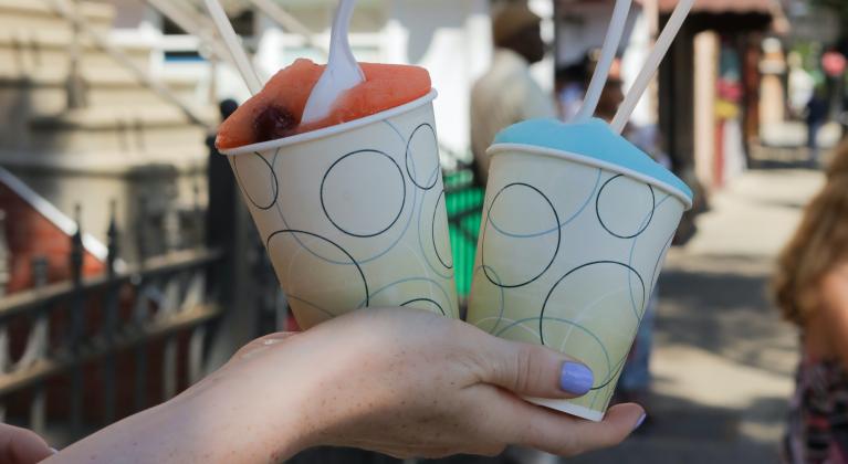 A hand holds up two snow cones